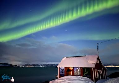 A very special Aurora over the sea house by the fjord