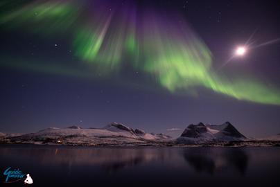 Full Moon Aurora over the snowy mountains by the fjord