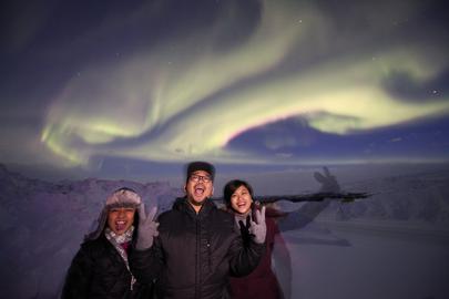 Happy people under the sky of the Northern Lights