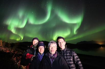 A family on four people under a star formed Northern Lights.